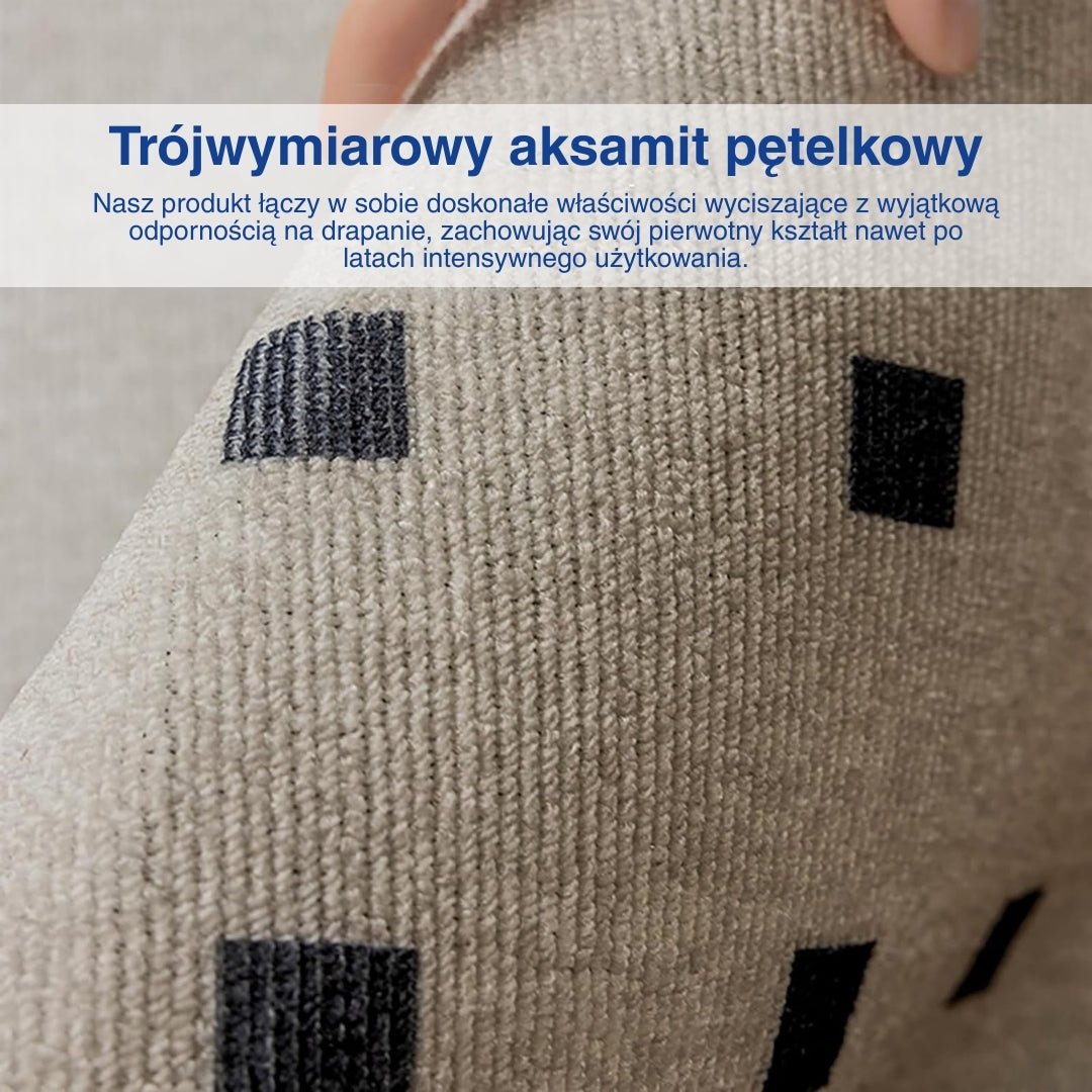 Ręka pokazująca ciemne kwadratowe wzory na białym dywanie.