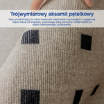 Ręka pokazująca ciemne kwadratowe wzory na białym dywanie.