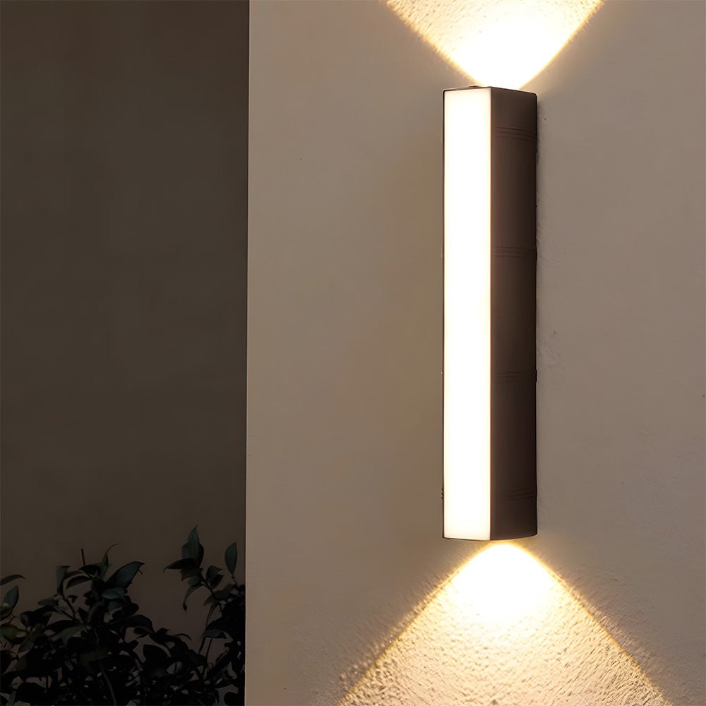 Nowoczesna zewnętrzna lampa LED włączona na białej ścianie.